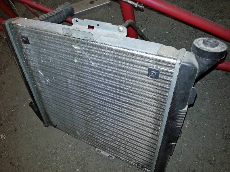 lot 1471 image: Rear engine dragster light weight aluminum radiator and B&M 12 volt electric cooling fan attached