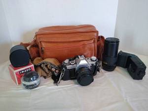 lot 1975 image: Vintage Canon AE-1 with a Makinon extended lens, Vivitar zoom thyristor 3000 and a light meter in bag