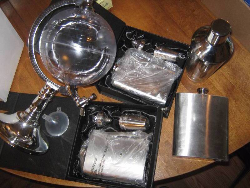 lot 3135 image: Globe Liquor Dispenser, 1 Flask (18 oz.), 2 Flasks (8 oz.) with 4 metal shot glasses each, glass shaker with metal lid.