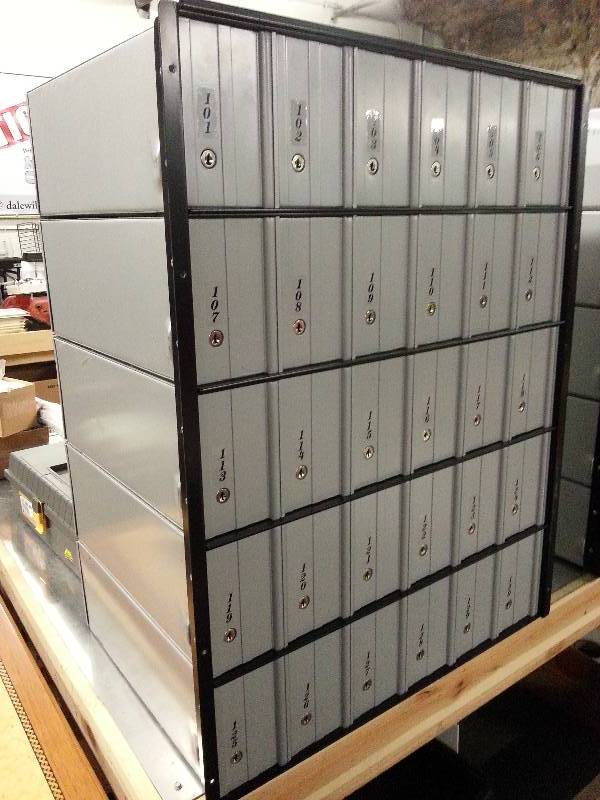 lot 1513 image: From a Mail Boxes and More that has closed store is this mail box lock set of 30 boxes #101 thru #130 made to be built in the wall.  Most keys are included, a few have been lost.