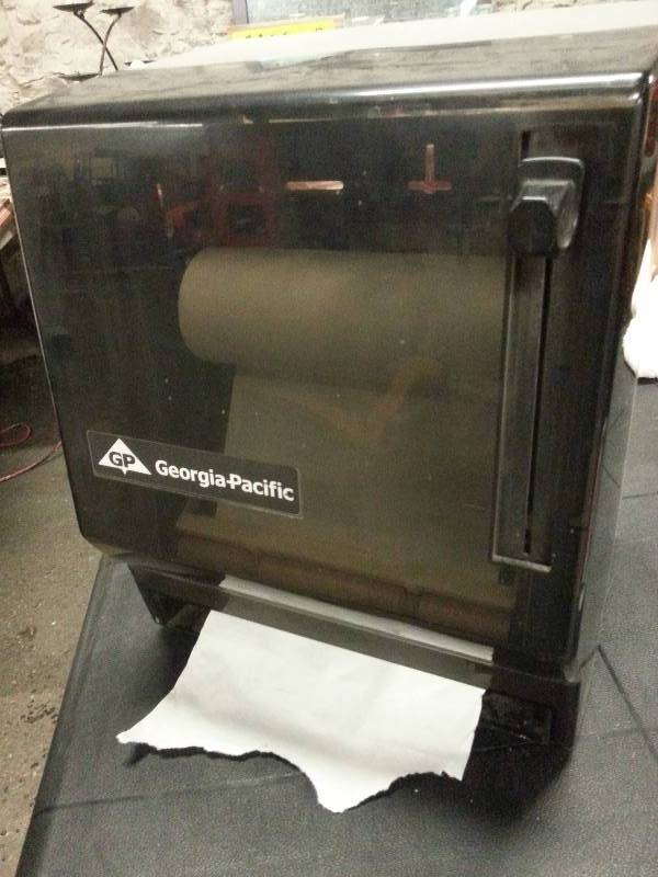 lot 1539 image: Good looking paper towel roll dispenser for the bathroom or garage shop.  Clean up your act with this smoked dark dispenser.  small towel roll included.