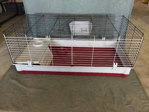 lot 4249 image: MidWest Wabbitat Deluxe Rabbit Home With Grass Feed Holder And Shelf With Bowl - Upper Wire Frame AndPlastic Bottom Base - Red And Tope Colored Base