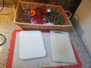 lot 3060 image: Lot of Cookie cutters with Easy Clean Rubber Sticky Matt and 2 Cutting Boards. Basket Included