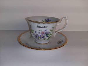 lot 2701 image: Tea Cup And Saucer - Month Of September Cup - Ceramic With Purple Flower Design - Gold Toned Rim
