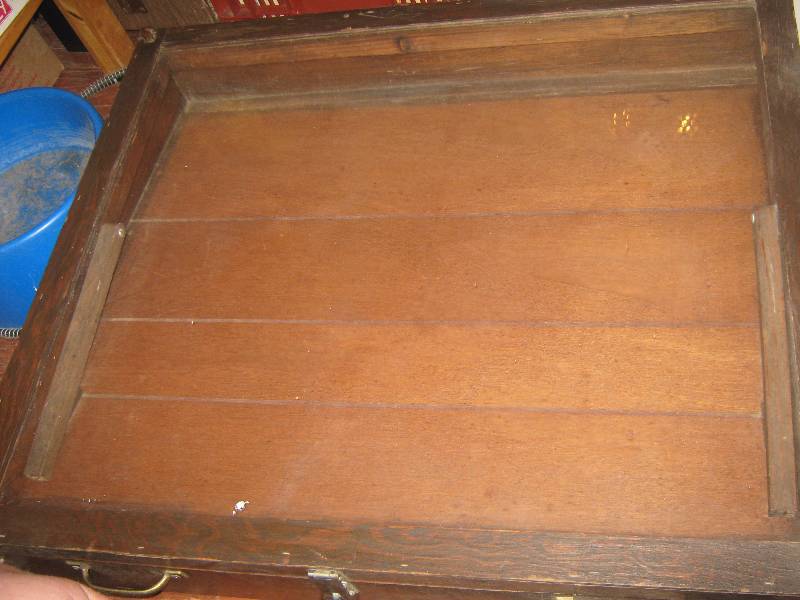 lot 7005 image: Large handmade wooden display cabinet, angled top, hinged cracked glass, brass carrying handles
