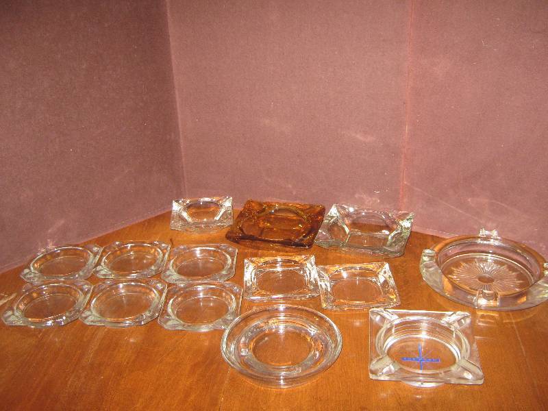 lot 7094 image: Glass ashtray lot, most are clear or amber colored glass a few may have advertising