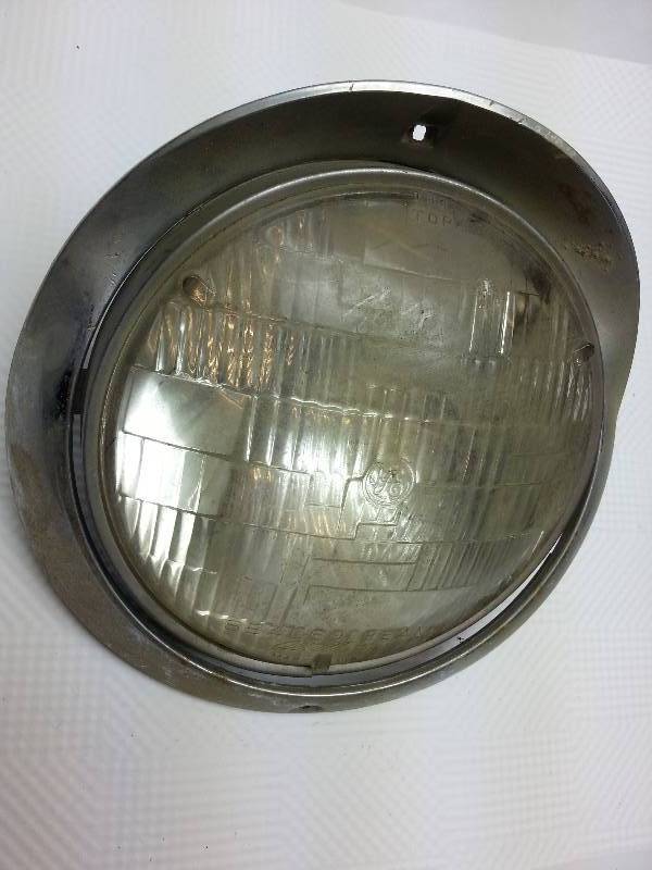 lot 1876 image: Pretty nice single headlight bucket and chrome bezel with headlight for the 1955 Chevrolets