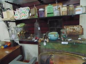 lot 3870 image: Contents of Bottom Shelf - Planters Peanut Jar - License Tags - Roseville Vase and more
