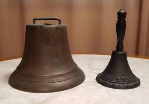 lot 105 image: Antique Brass Bell (6.5 in. base) and Good Health Cast Iron Hand Bell (6 in. tall)
