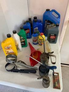 lot 891 image: Full & Partial bottles of Transmission fluid, Oil, Power Steering fluid, brake fluid, oil cans, grips, funnels