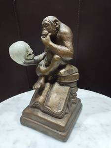 lot 1180 image: Austin Productions Darwin monkey with skull sculpture approximately 10 in tall