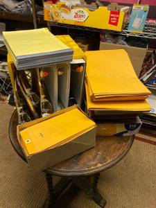 lot 21695 image: miscellaneous lot with large binders clipboards yellow legal size note paper large manila envelopes with clasp small manila envelopes with clasp sheet protectors file folders and miscellaneous colored paper