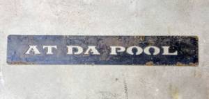 lot 28017 image: Metal Sign says AT DA POOL - 31.5 x 5
