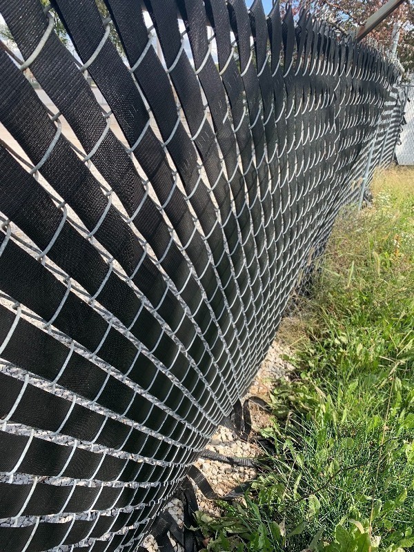 lot 951 image: Two rolls of vinyl webbing 100 yards each dress up your chain link fence as pictured
