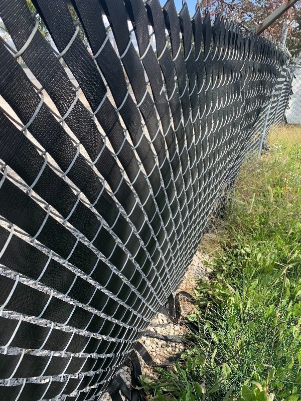 lot 954 image: Two rolls of vinyl webbing 100 yards each dress up your chain link fence as pictured