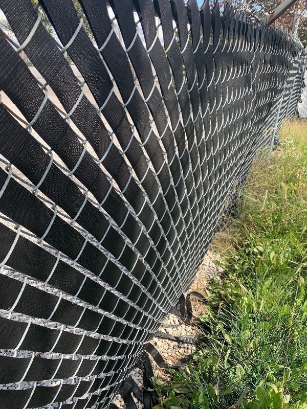 lot 955 image: Two rolls of vinyl webbing 100 yards each dress up your chain link fence as pictured