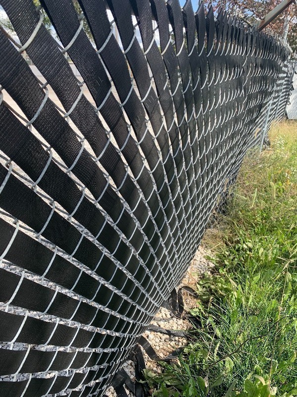 lot 956 image: Two rolls of vinyl webbing 100 yards each dress up your chain link fence as pictured