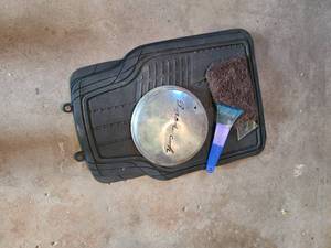 lot 2067 image: 1951 Buick script hub cap with 2 bullet holes, car floor liners, ice scrapers