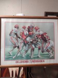 lot 4221 image: framed print of Oklahoma versus Nebraska football has one break in upper left corner glass 30 and 12 in wide 24 and 12 in tall