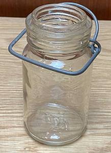 lot 9058 image: Small Clamp Top Glass Jar Embossed reads  K   1877   8  on the bottom