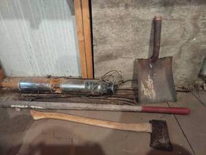 lot 4124 image: The Rusteer with rebar an axe and a shovel needing a repaired handle