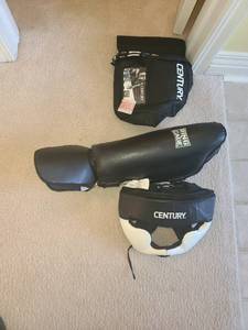 lot 1743 image: Century Boxing helmet with ring to cage shin and ankle pads. Size large