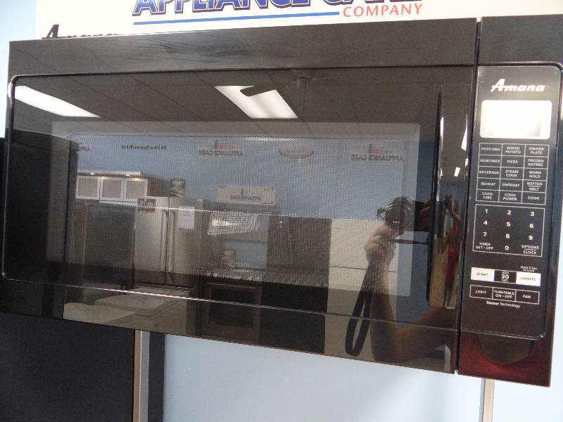 lot 1063 image: BRAND NEW Amana Black Over The Range Microwave