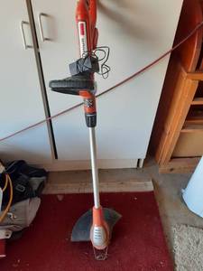 lot 2023 image: Black and Decker weed eater. Has a charger but NO battery