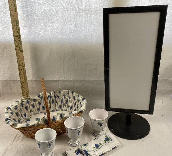 lot 6262 image: Material Lined Wicker Basket, Matching Cups & Napkins & Metal Framed Pic. Sign