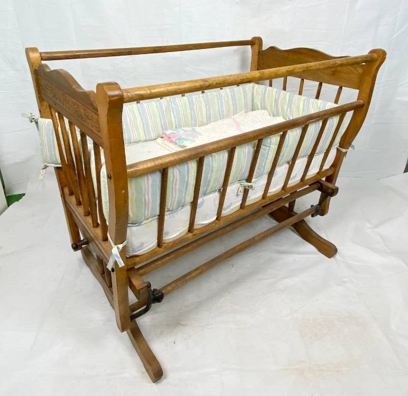 lot 6389 image: Vintage Hand Made BABY CRADLE - This is SO Beautiful You Must See Patented Cast Iron Hardware - Beautiful Wood - Made with love by Great Grandpa back in the early 1900s - Has a Swing Stop and All Bedding Shown - Clean and Nice