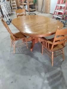 lot 9 image: HW Hull and sons 48-in round oak table with 24-in leaf two Captains chairs and one side chair