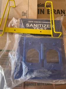 lot 4230422 image: Safety Data sheet rack, sanitizer test station, and bag opener