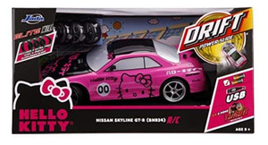 lot 25 image: Jada Toys Hello Kitty Nissan Skyline GT-R (Bnr34) Drift Power Slide Elite RC, USB Charging, with 4 Extra Tires, Pink