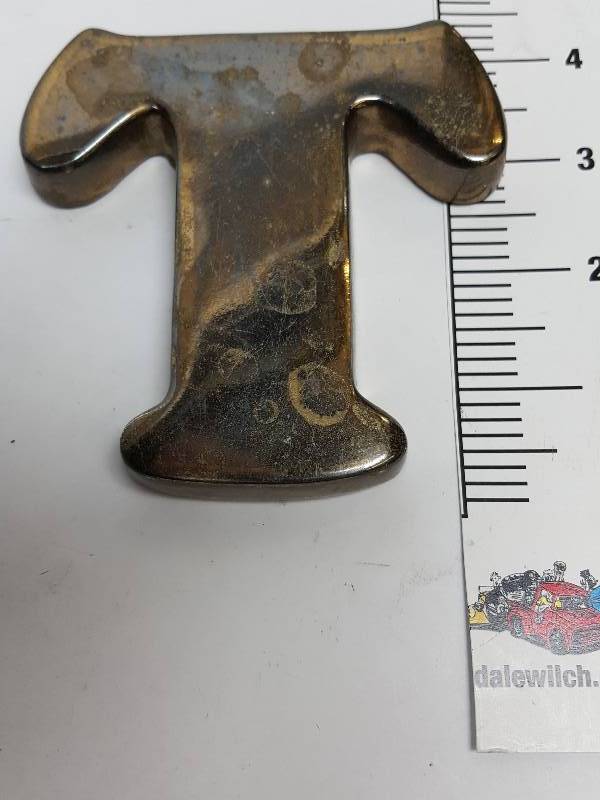 lot 9194 image: I believe this heavy desk top paper weight is solid brass.  If the 4 tall T works for you, put your bid down.