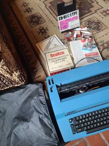lot 1312 image: IBM Selectric II typewriter with several extra typing element balls, typing paper, more