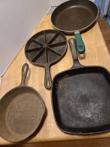 lot 1640 image: Wagners cast iron skillet with seasoning instructions on bottom, cast iron cornbread skillet and 8 round pan plus a T Fal skillet