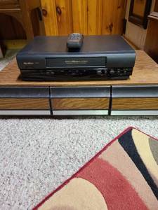 lot 2001 image: Quasar VCR with remote, tape storage and tapes