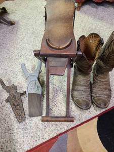 lot 2014 image: Old boot jacks, one is wooden spring action collapsible, and cowboy boots. Iron boot jack on left broken