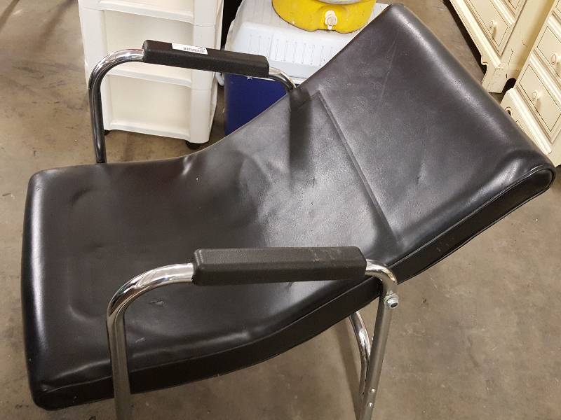 lot 1062 image: Cant figure this in position Black and chrome lay back recliner made for watching TV on the high rack