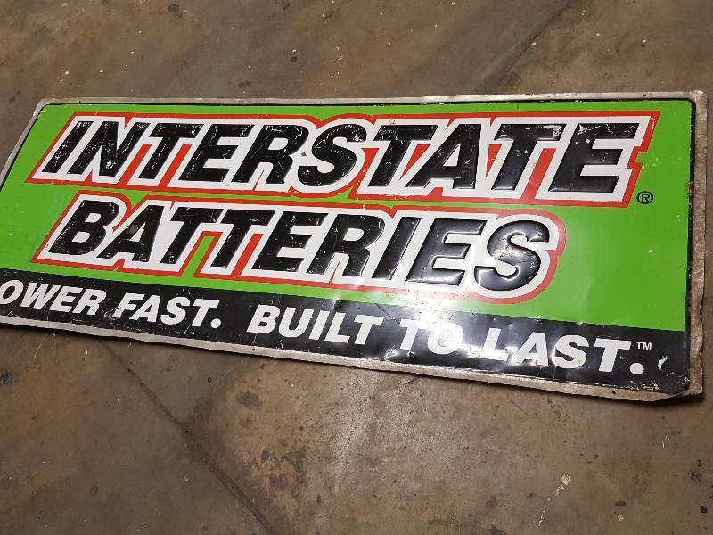 lot 1169 image: Dress up the shop with this 5 foot X 2 foot metal Interstate Batteries sign with slightly wrinkled corner