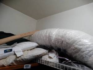 lot 1336 image: All Contents On top Shelf in Closet  Body Pillow  Bags  T- Shirts  Misc