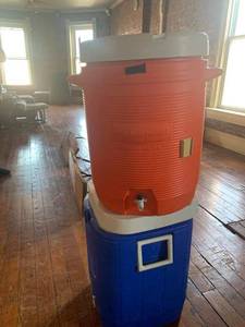 lot 6976 image: Blue Coleman Water Cooler and a Rubbermaid Water Cooler