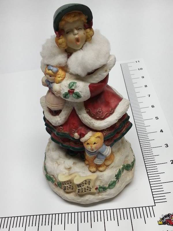 lot 8336 image: Christmas Caroler with wind up music box in the bottom.  Her head moves from side to side