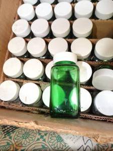 lot 1059 image: Partial Case of Small Lidded Green Glass Bottles and More