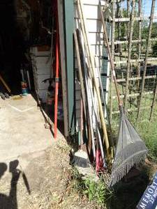lot 1308 image: Long Handled Tools Outside of Garage