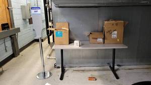 lot 22569 image: 5ft Rectangular Gray Laminate Table and a Purell Hand Sanitizer Station