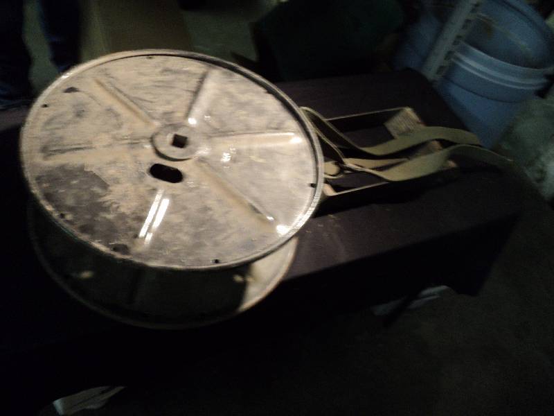 lot 5033 image: Mixed lot (1) Crosby RL-159 Metal Spool, Olive Drab (1) Metal Wheel Chock with Olive Drab Strap