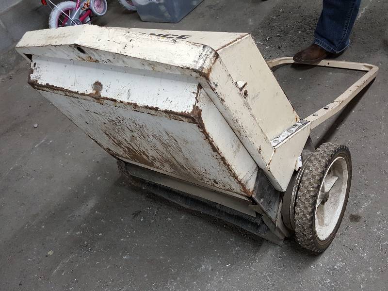lot 2036 image: Missing the front caster wheel but still works great if you hold it up off the floor is this powerful man powered push sweeper