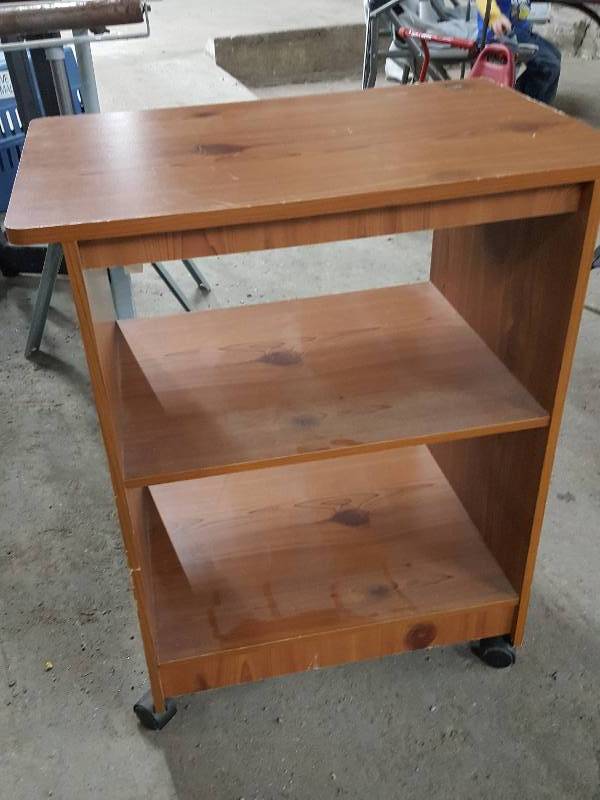 lot 2181 image: Simple wood 3 tire shelf  TV stand on casters for easy locating 28 tall.  Slight water damage on top