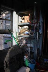lot 18035 image: Misc Contents Just Inside Door of House  Travel Chest  Metal Rack 